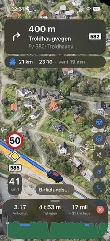 Vegferd under kjøring: sving til høyre om 400 meter inn på Troldhaugvegen, fartsgrense 50, og ferja 21 km fram med avgang 23:10 og 19 minutters venting regnet inn i ankomsttiden
